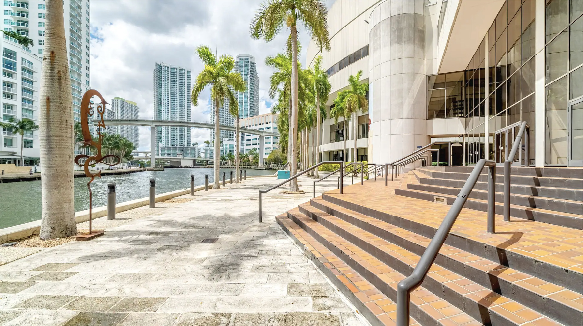 A hotel room featuring 2 freshly made beds and a view of the blue sky over Miami.
