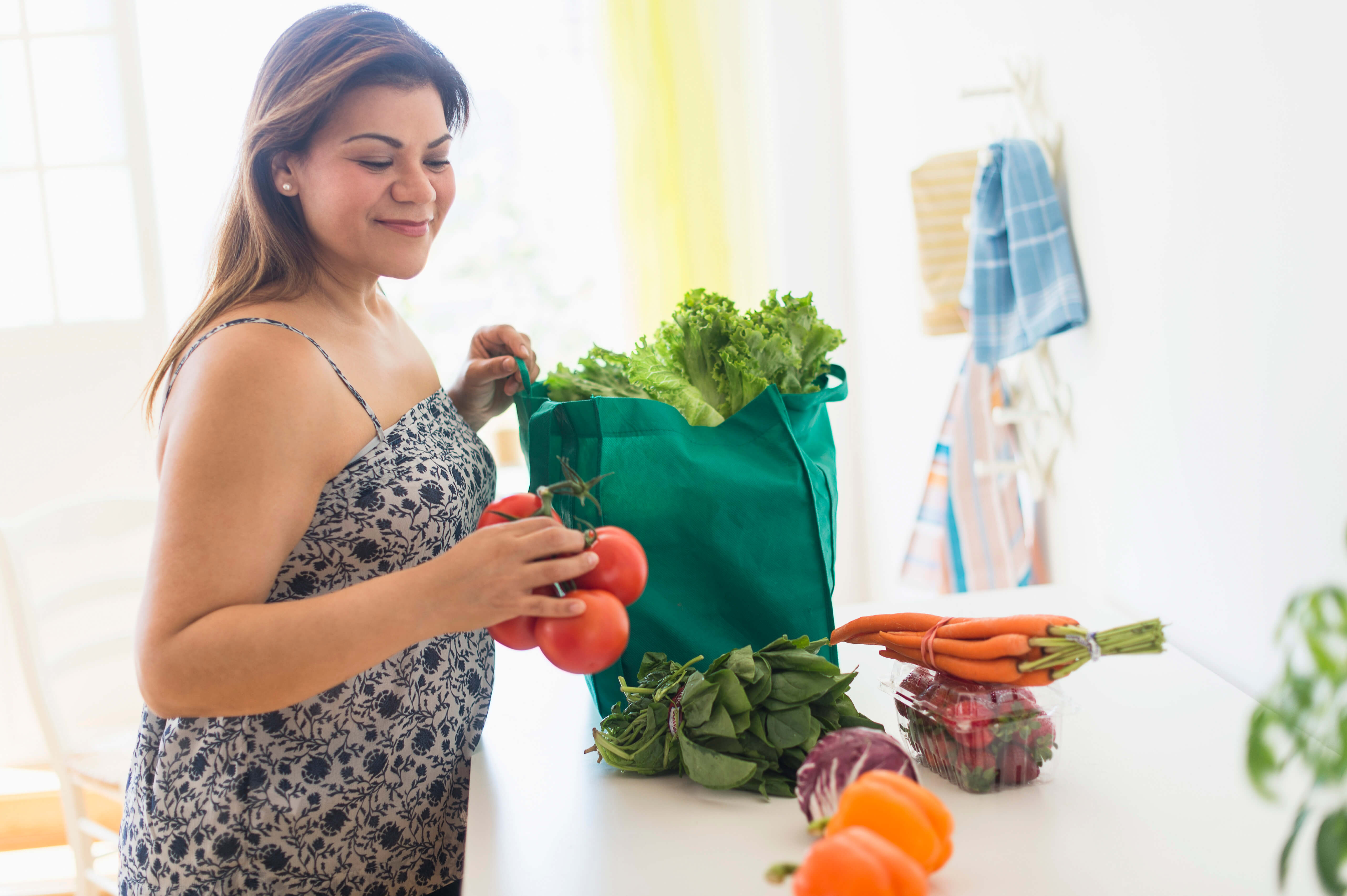 Mujer sacando alimentos de una bolsa