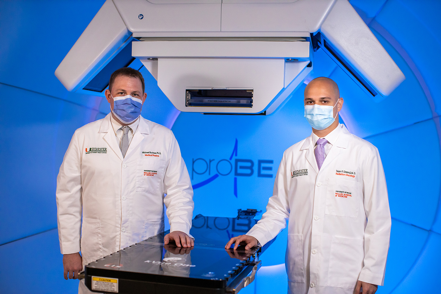Dr. Butkus & Dr. Diwanji pose for a photo in front of the cyclotron