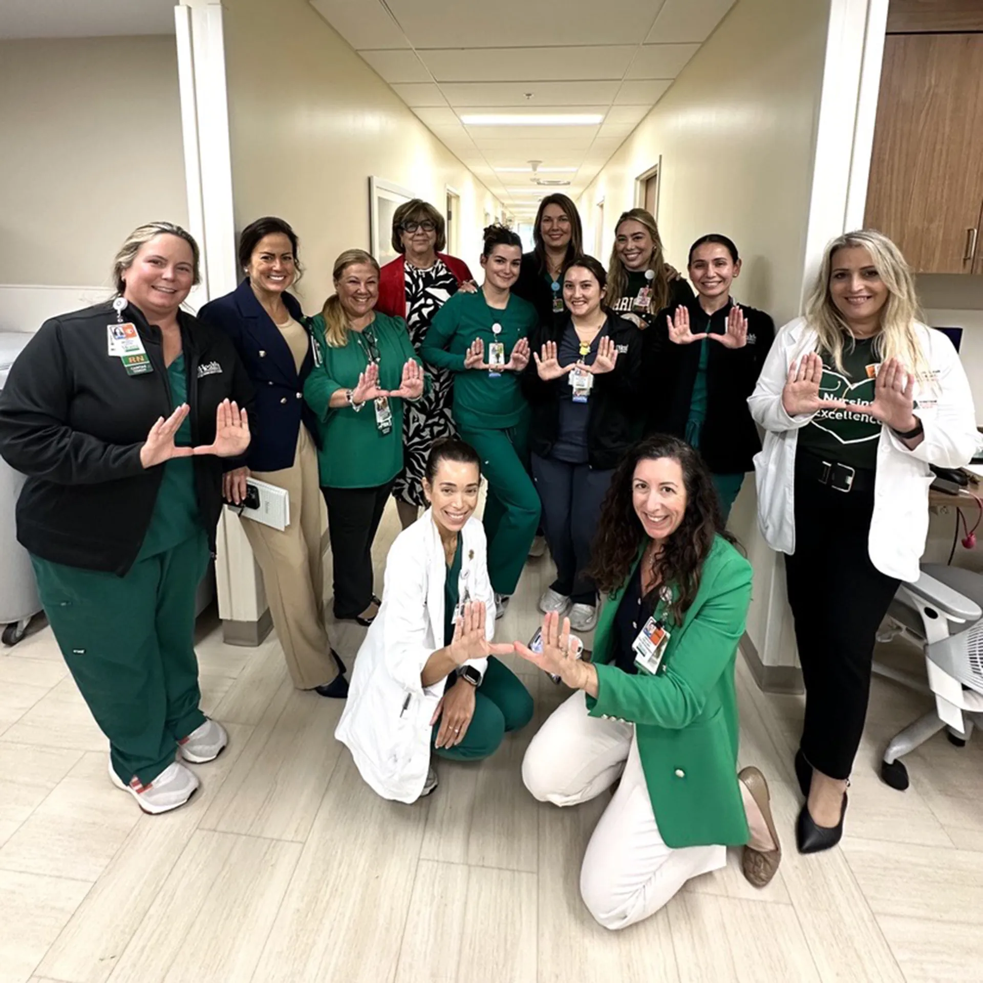 Group of nurses pose for a group photo in a hallway